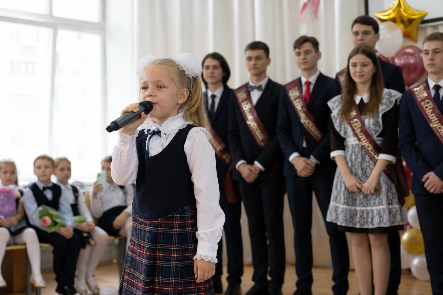 Первоклассники поют песню выпускникам начальной школы на последнем звонке